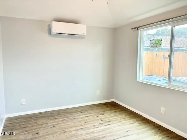 a view of a room with wooden floor and window