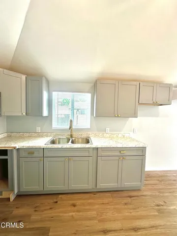 a view of a kitchen with stainless steel appliances granite countertop a sink and cabinets