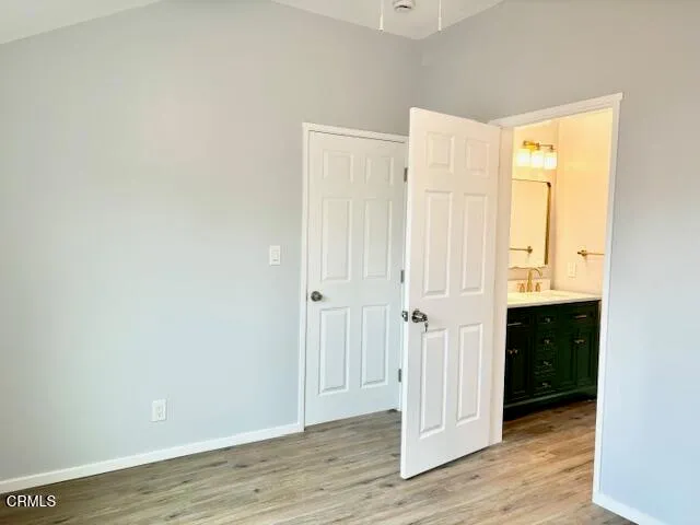 a view of an empty room with wooden floor and closet