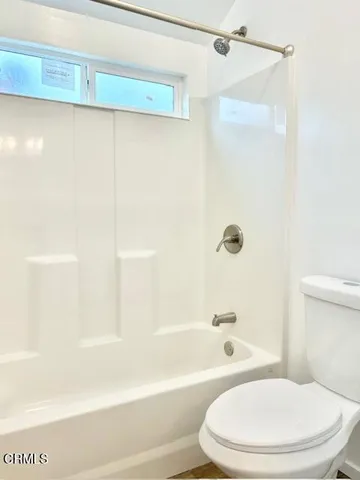 a white toilet and tub sitting next to a bathroom sink