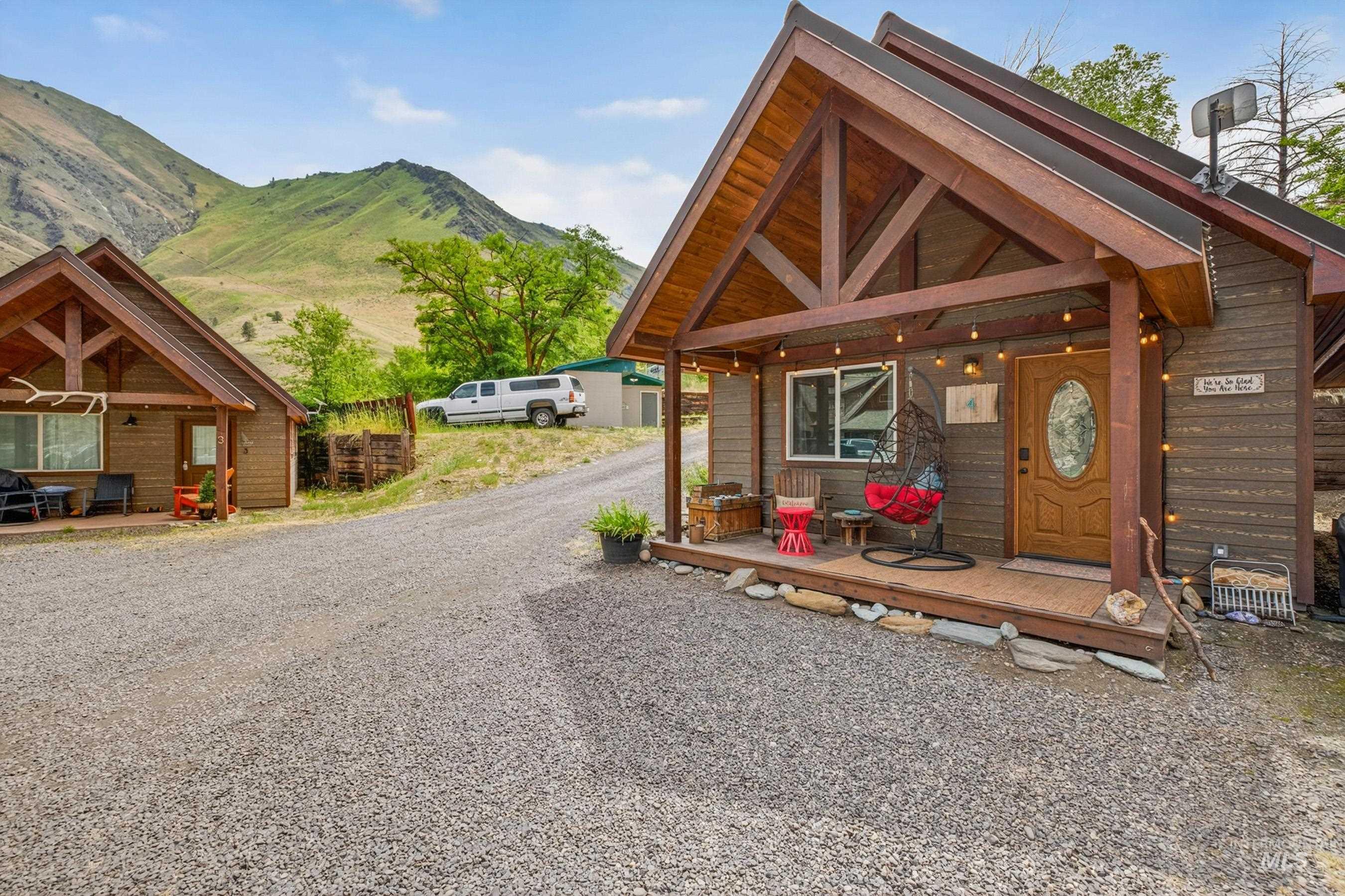 1432 Salmon Drive Riggins, ID 83549 - Photo 25 of 39 Cabin-style dwelling featuring a covered front porch with exposed timber framing and a decorative glass-paneled entry door