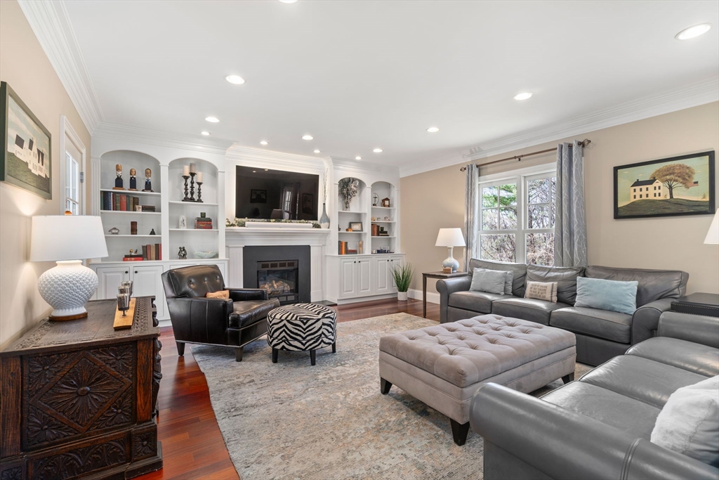 47 Brewster Road Sudbury, MA 01776 - Photo 15 of 41 a living room with furniture a fireplace and a flat screen tv