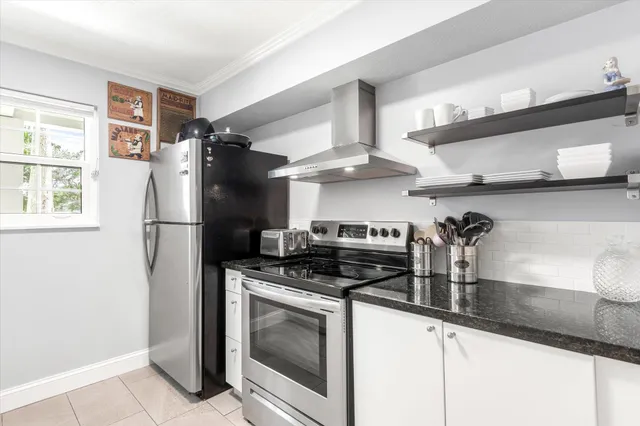 a kitchen with granite countertop a sink stove and cabinets