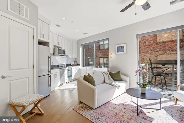 a living room with furniture a dining table and a refrigerator