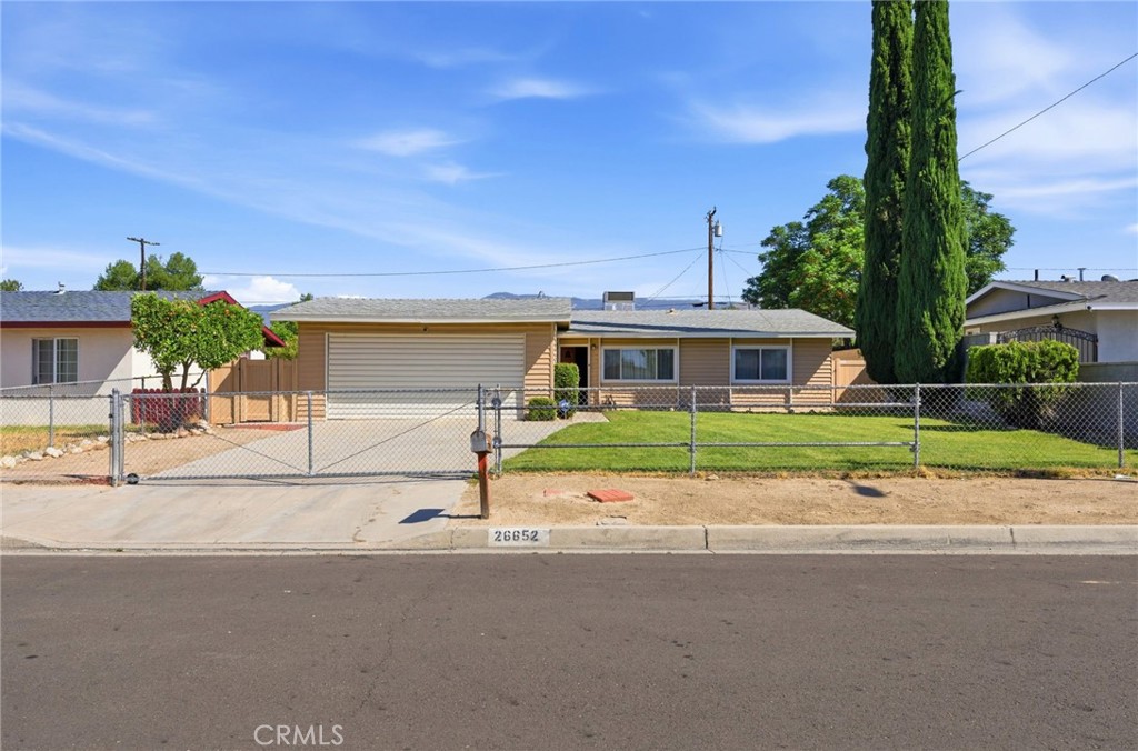 front view of house with a yard and potted plants