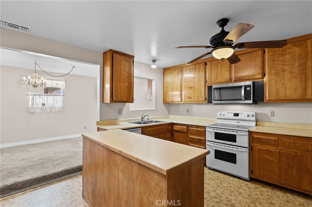 26652 7th Street Highland, CA 92346 - Photo 8 of 27 a kitchen with stainless steel appliances a stove microwave and a sink