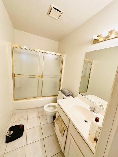 4448 Chaha Road, Unit 205 Garland, TX 75043 - Photo 4 of 5 Bathroom featuring a tub with sliding shower doors, a single vanity with an integrated sink, a wall-mounted mirror, and tile flooring