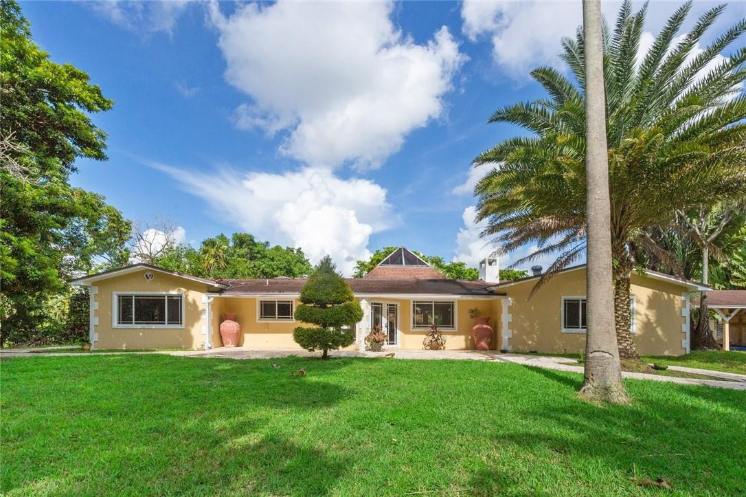 6311 Melaleuca Road Southwest Ranches, FL 33330 - Photo 1 of 33 a front view of a house with a garden