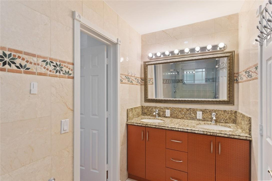 6311 Melaleuca Road Southwest Ranches, FL 33330 - Photo 26 of 33 a bathroom with a granite countertop sink a mirror and a vanity