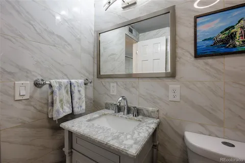 a bathroom with a granite countertop sink and a mirror