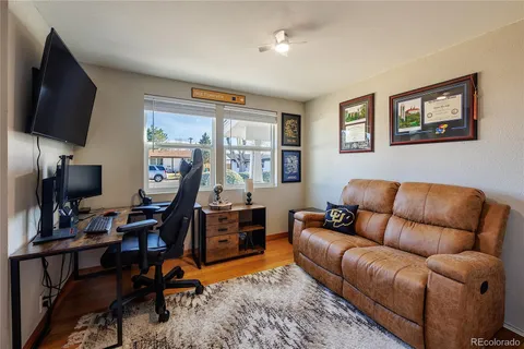 a living room with furniture a flat screen tv and kitchen view