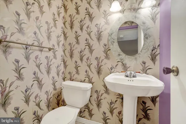 a bathroom with a sink and mirror with toilet