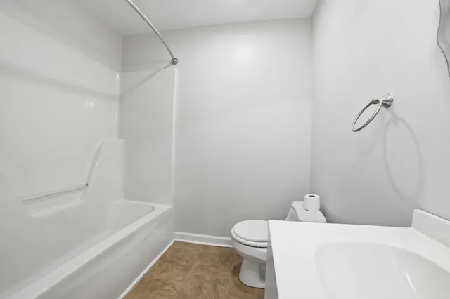 a white toilet sitting next to a bath tub