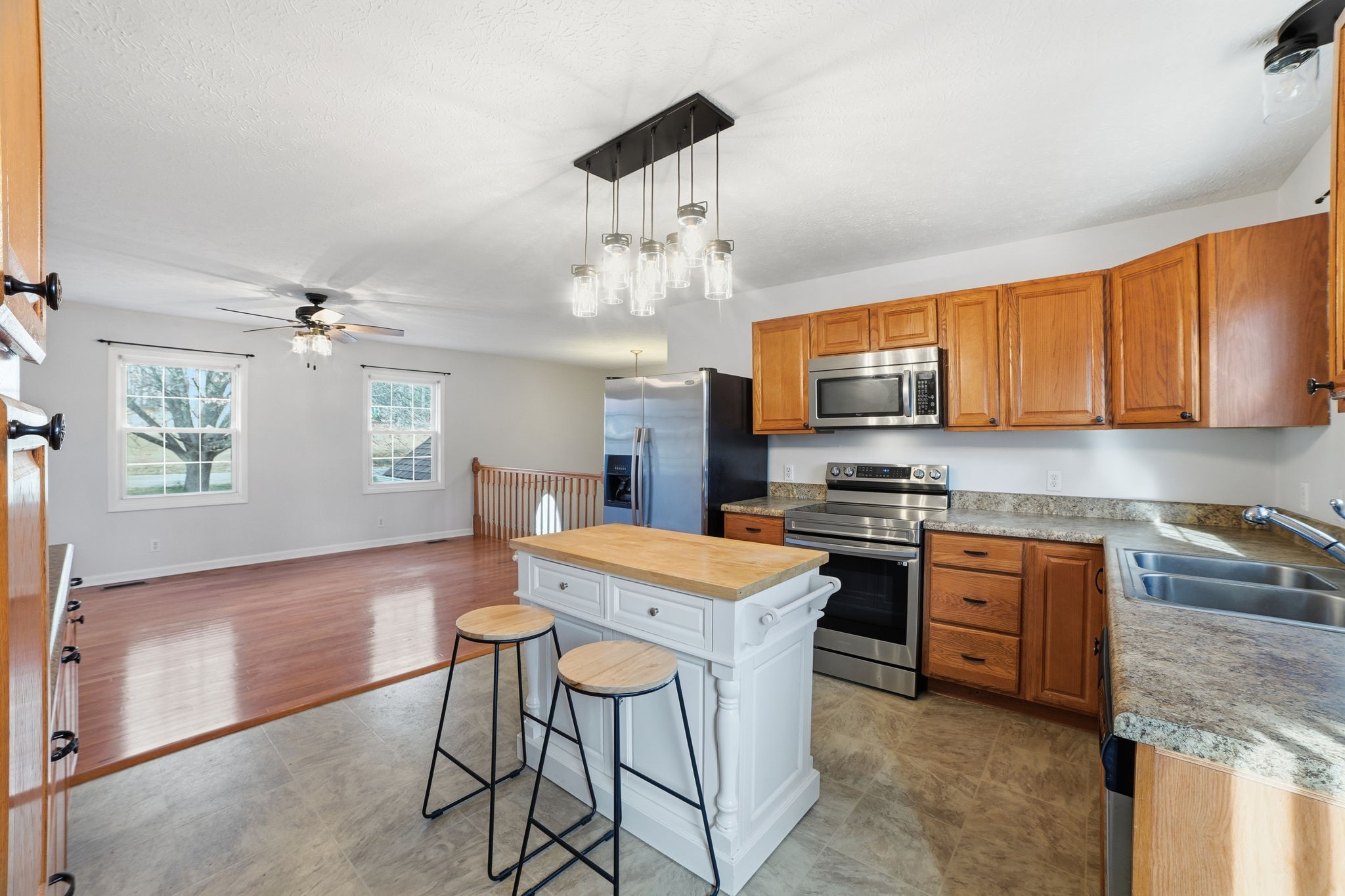 1130 Windsor Circle Lyles, TN 37098 - Photo 7 of 26 a kitchen with stainless steel appliances granite countertop a stove top oven a refrigerator a sink dishwasher a dining table and chairs with wooden floor
