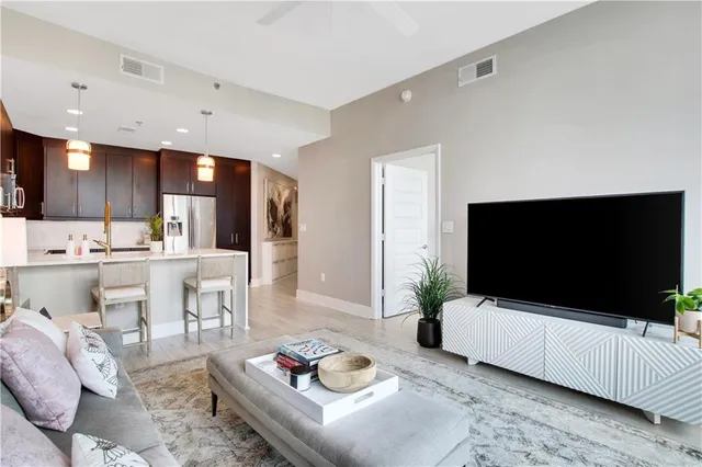 a living room with furniture a flat screen tv and kitchen view