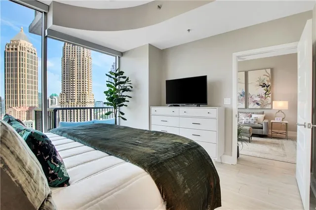 a bedroom with a balcony a bed and a flat screen tv