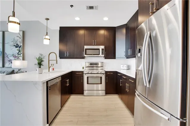 a kitchen with stainless steel appliances granite countertop a refrigerator and a stove