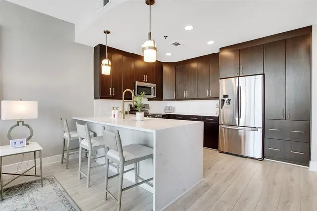 a kitchen with kitchen island a counter space a sink appliances and cabinets