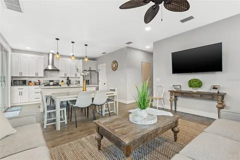 a kitchen with stainless steel appliances granite countertop a kitchen island a table and chairs in it