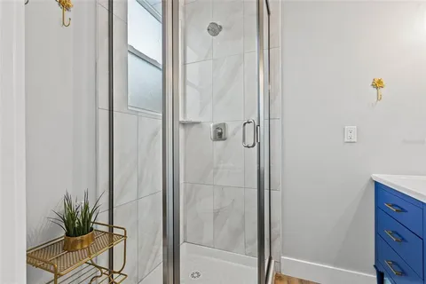 a large white kitchen with a sink a window and stainless steel appliances