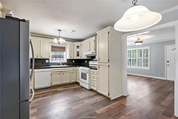 a kitchen with white cabinets and white appliances