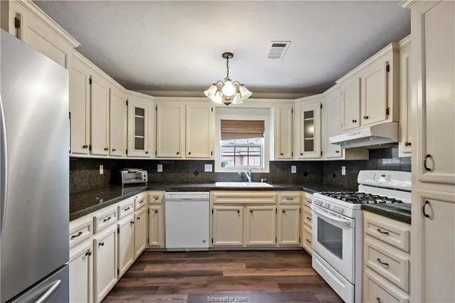 a kitchen with white cabinets and white appliances