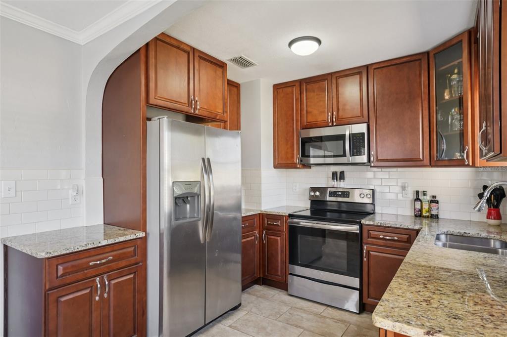4809 33rd Avenue North St. Petersburg, FL 33713 - Photo 20 of 62 a kitchen with stainless steel appliances granite countertop a refrigerator stove microwave and sink