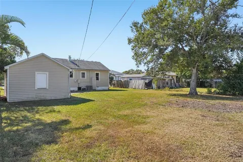 a front view of a house with a yard and potted plants