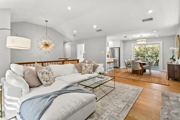 a living room with furniture potted plant and a chandelier