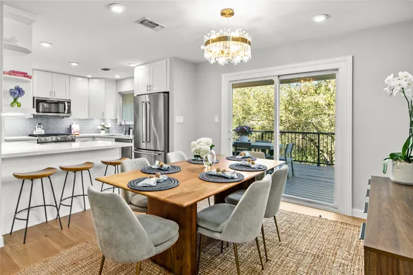 a dining room with furniture a large window and kitchen view
