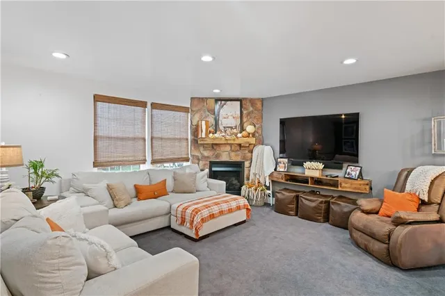 a living room with couches and kitchen view with wooden floor