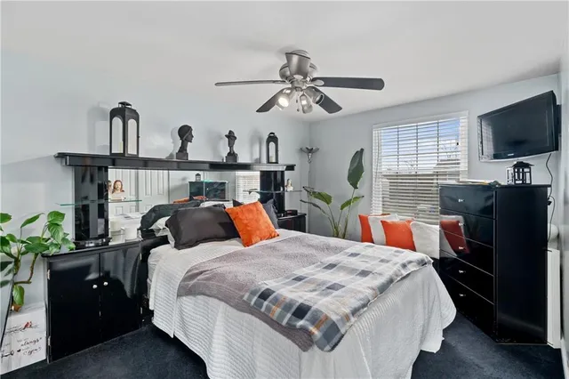 a bedroom with a bed chandelier and a window