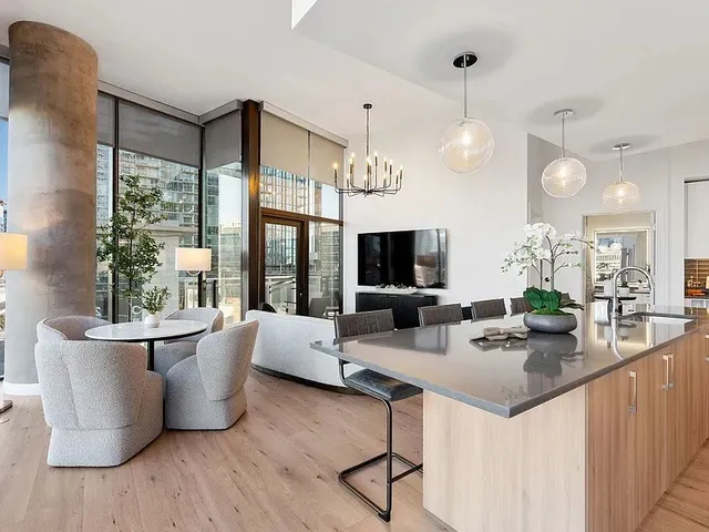 a living room with furniture kitchen view and a wooden floor