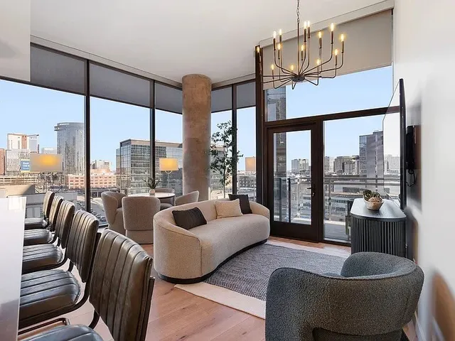 a kitchen with stainless steel appliances granite countertop a refrigerator a stove a sink dishwasher a dining table and chairs with wooden floor