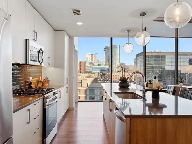 a large kitchen with a large window appliances and cabinets