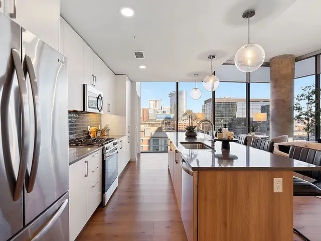 a kitchen with stainless steel appliances granite countertop a stove a sink and a microwave