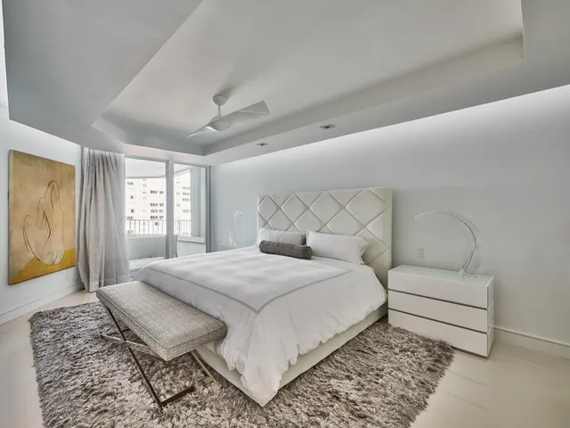 a bedroom with a bed and a dresser next to a window