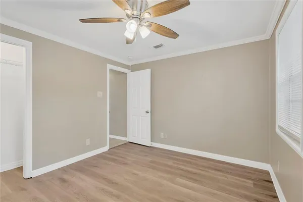 an empty room with a window and a fan