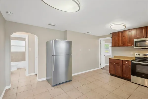 a kitchen with stainless steel appliances granite countertop a refrigerator a stove a sink and a microwave