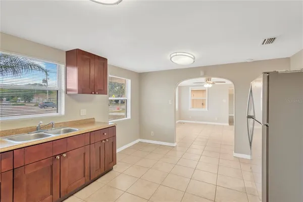 a kitchen with a sink a refrigerator and cabinets