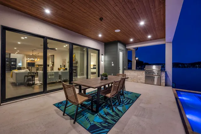 a view of a dining room with furniture a kitchen and chandelier