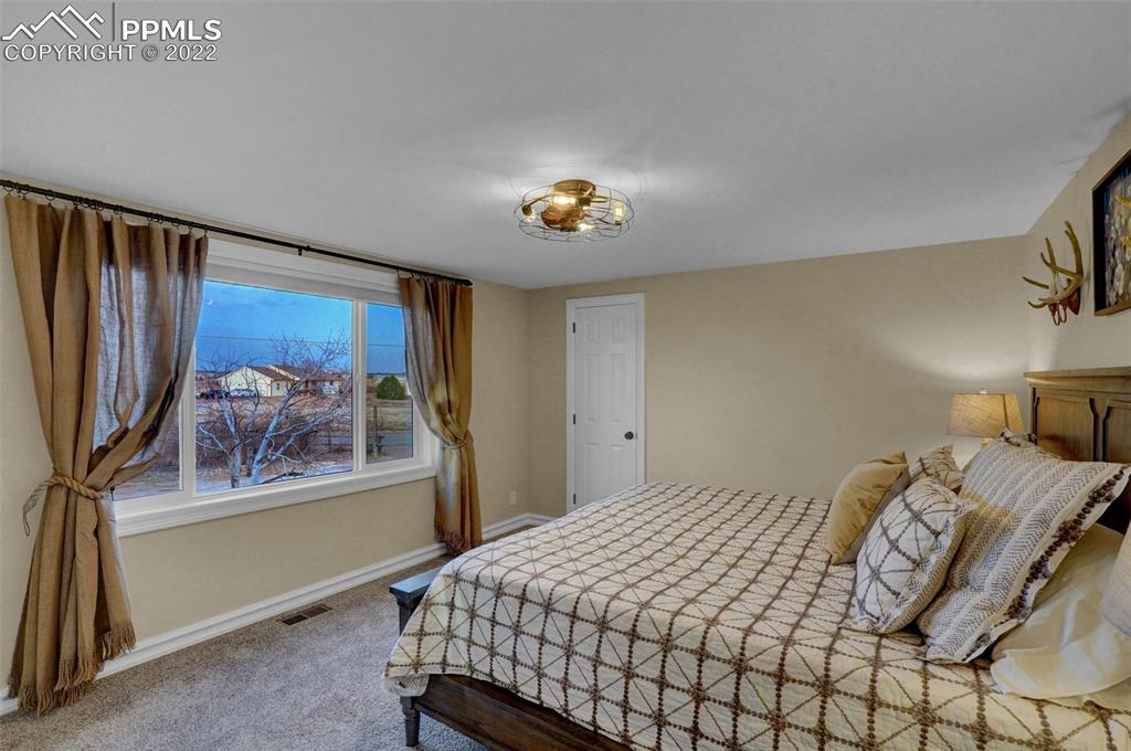 1451 R Street Penrose, CO 81240 - Photo 17 of 50 a bedroom with a bed and a painting on the wall