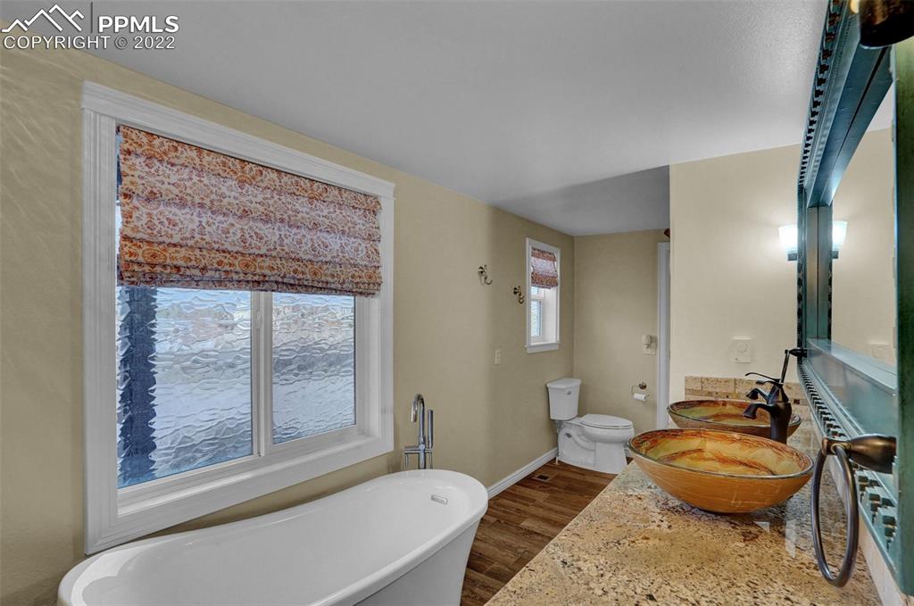 1451 R Street Penrose, CO 81240 - Photo 20 of 50 a spacious bathroom with a granite countertop tub a sink and a large mirror
