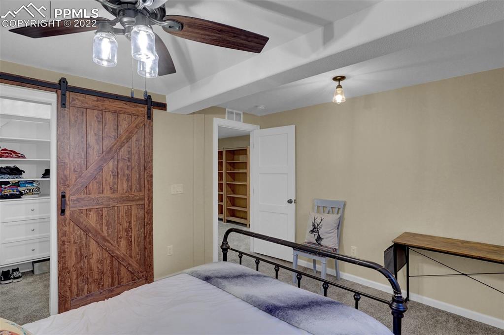 1451 R Street Penrose, CO 81240 - Photo 30 of 50 a bedroom with a bed and a chandelier