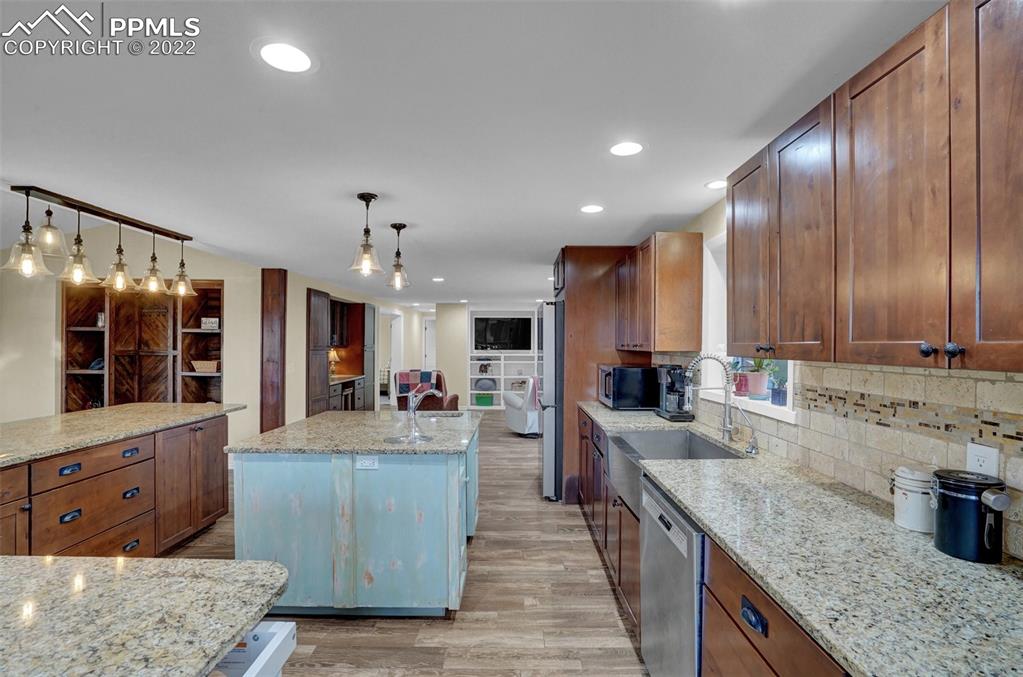 1451 R Street Penrose, CO 81240 - Photo 9 of 50 a large kitchen with stainless steel appliances granite countertop plenty wooden cabinets counter space a sink and wooden floor