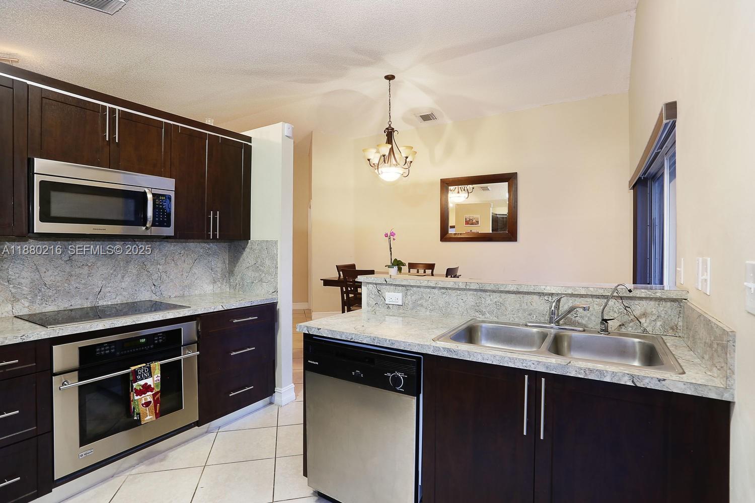14285 Southwest 176th Terrace Miami, FL 33177 - Photo 11 of 20 a kitchen with a sink and stove top oven
