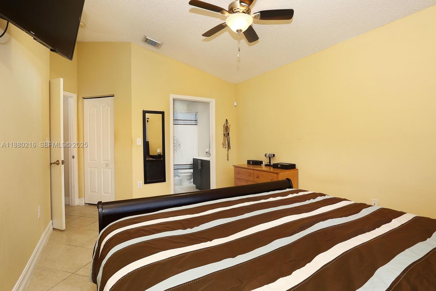 14285 Southwest 176th Terrace Miami, FL 33177 - Photo 14 of 20 a bedroom with a bed and a chandelier