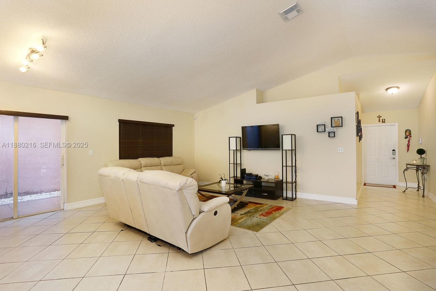 14285 Southwest 176th Terrace Miami, FL 33177 - Photo 5 of 20 a living room with furniture and a flat screen tv
