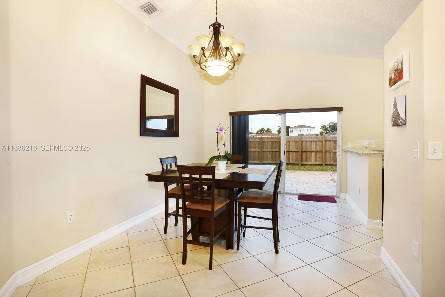 14285 Southwest 176th Terrace Miami, FL 33177 - Photo 7 of 20 a view of a dining room with furniture and a chandelier