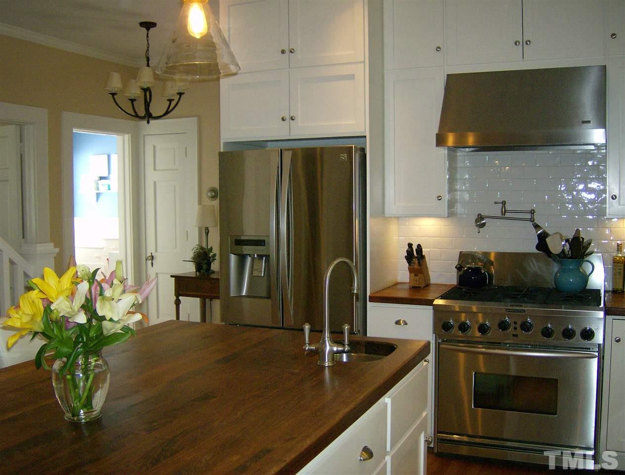 919 West Johnson Street Raleigh, NC 27605 - Photo 6 of 20 a kitchen with stainless steel appliances a stove a refrigerator a sink a counter space and cabinets